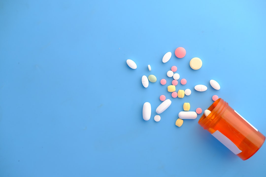 spilled prescription pills from a bottle on a blue background